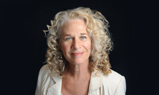 Portrait of Carole King against a black background